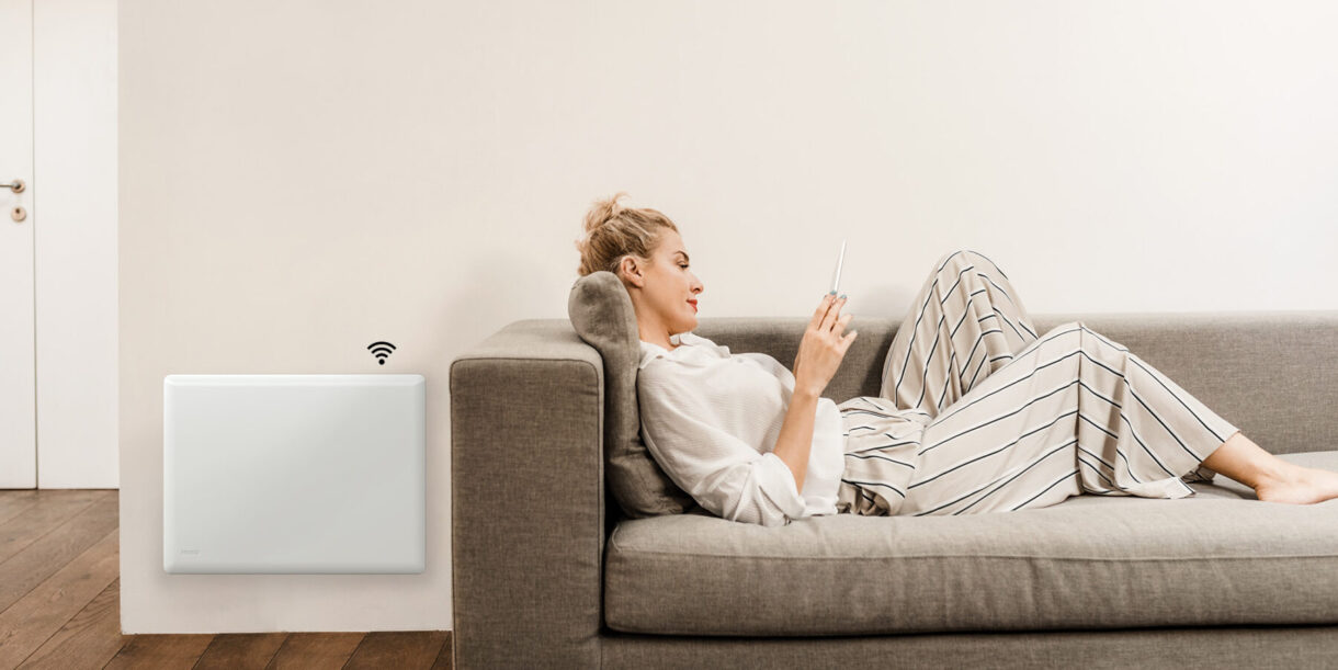 Θερμοπομπός NOBO NTL4R WiFi τοποθετημένος σε τοίχο δίπλα σε καναπέ σαλονιού